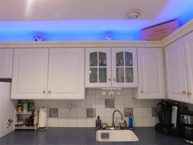 74 Bon Aire Cir Unit Q10, Suffern, NY 10901 - kitchen featuring a sink, dark countertops, white cabinets, tasteful backsplash, and glass insert cabinets