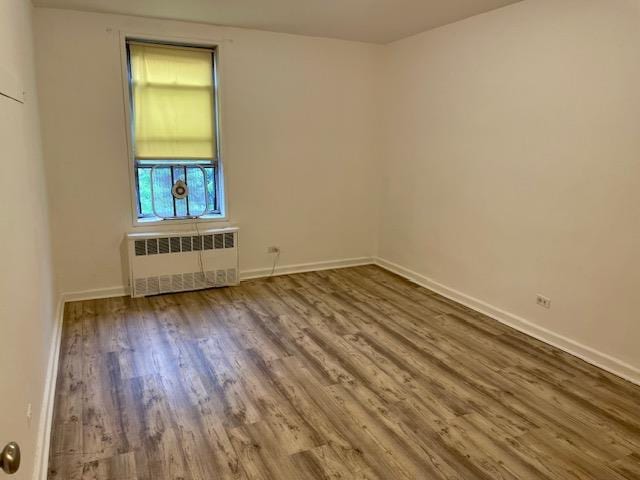 33-45 92nd St Unit 4K, Jackson Heights, NY 11372 - spare room featuring radiator, wood finished floors, and baseboards