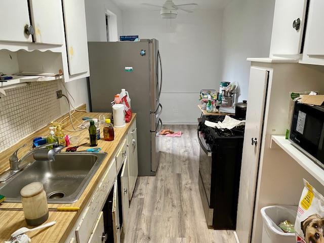33-45 92nd St Unit 4K, Jackson Heights, NY 11372 - kitchen with black appliances, a sink, white cabinets, and light wood-style flooring