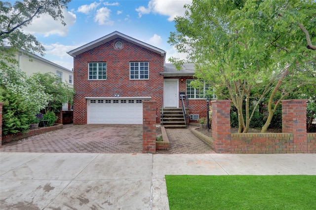 316 Oriental Blvd, Brooklyn, NY 11235 - tri-level home featuring a garage, decorative driveway, and brick siding