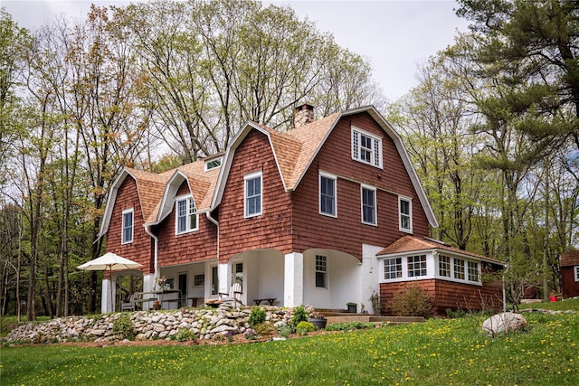 57 Dellenbaugh Rd, Cragsmoor, NY 12566 - view of front of house featuring a gambrel roof, a chimney, a shingled roof, and a front yard
