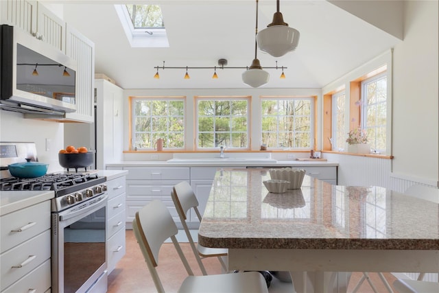 57 Dellenbaugh Rd, Cragsmoor, NY 12566 - kitchen featuring appliances with stainless steel finishes, a skylight, white cabinets, and a kitchen bar