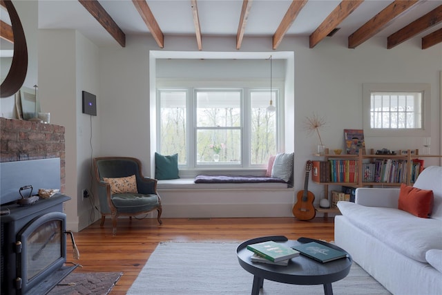 57 Dellenbaugh Rd, Cragsmoor, NY 12566 - living room featuring beam ceiling, healthy amount of natural light, wood finished floors, and a wood stove