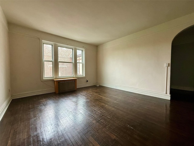 1440 Midland Unit 5F, Bronxville, NY 10708 - empty room with radiator, arched walkways, wood-type flooring, and baseboards