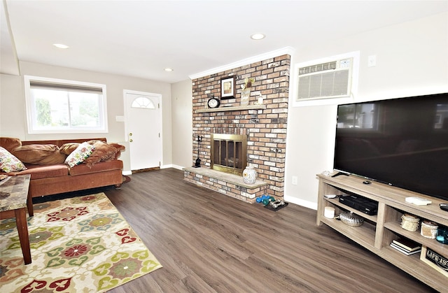 2 Walnut Dr, Syosset, NY 11791 - living room featuring a wall unit AC, dark wood finished floors, a brick fireplace, baseboards, and recessed lighting