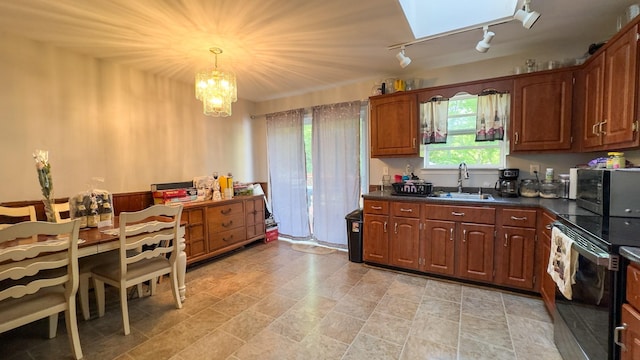 23 Kingsland Ave, Shirley, NY 11967 - kitchen featuring a sink, appliances with stainless steel finishes, dark countertops, a chandelier, and track lighting
