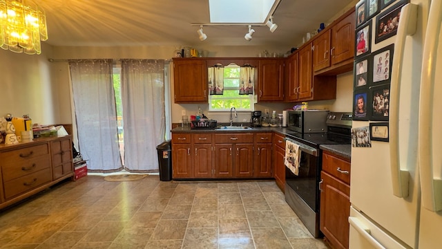 23 Kingsland Ave, Shirley, NY 11967 - kitchen with appliances with stainless steel finishes, dark countertops, a chandelier, a sink, and track lighting