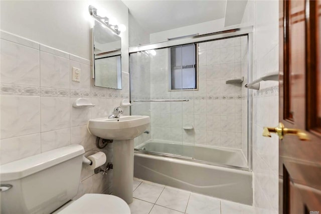 226-26 Union Tpke Unit 1E, Oakland Gardens, NY 11364 - bathroom featuring toilet, shower / bath combination with glass door, tile walls, and tile patterned flooring