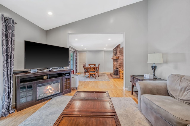 49 Rainbow Ln, Levittown, NY 11756 - living room featuring a brick fireplace, light wood finished floors, recessed lighting, baseboards, and high vaulted ceiling