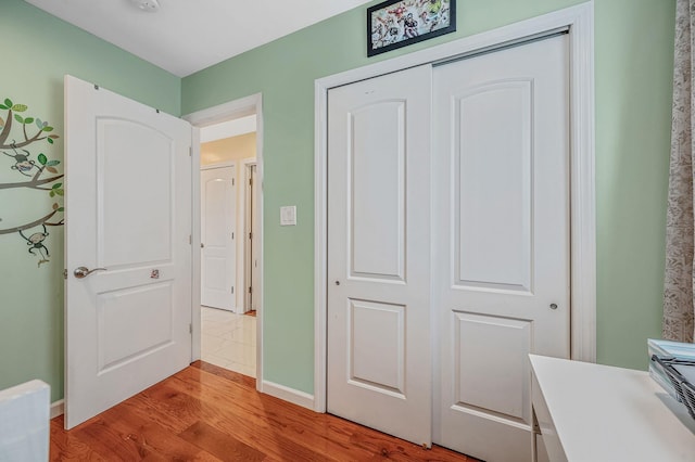 49 Rainbow Ln, Levittown, NY 11756 - unfurnished bedroom with light wood-style floors, a closet, and baseboards