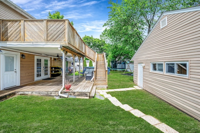 49 Rainbow Ln, Levittown, NY 11756 - view of grassy yard featuring a deck, french doors, a trampoline, ceiling fan, and stairway