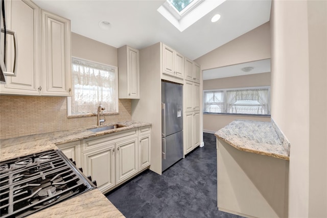9 Magnolia Pl Unit 1, Bronx, NY 10465 - kitchen featuring a sink, stainless steel fridge, decorative backsplash, a skylight, and light stone counters