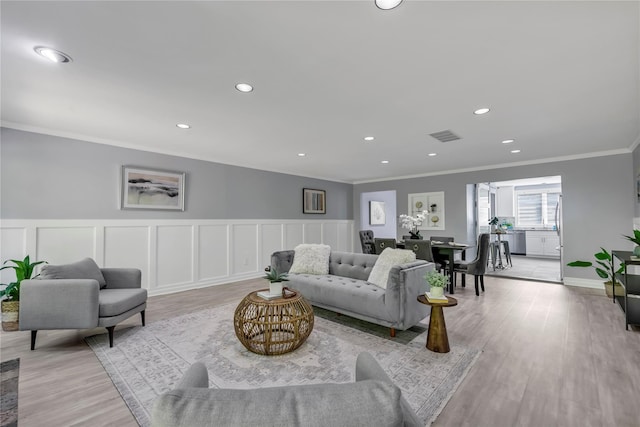 16 Sands Ct, Port Washington, NY 11050 - living area with ornamental molding, light wood finished floors, recessed lighting, wainscoting, and a decorative wall