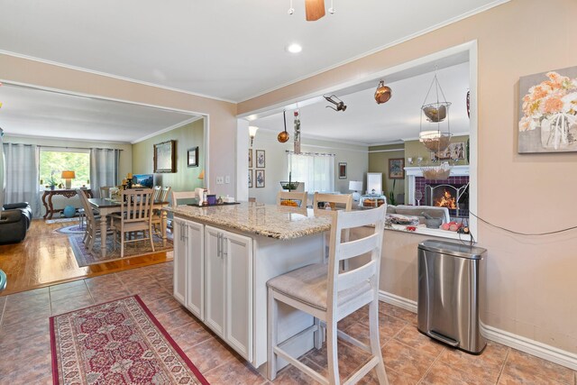 2975 Rte 9, Cold Spring, NY 10516 - kitchen with open floor plan, crown molding, white cabinetry, a brick fireplace, and light stone countertops