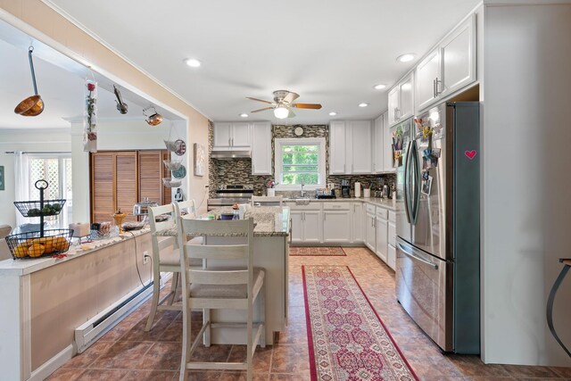 2975 Rte 9, Cold Spring, NY 10516 - kitchen featuring appliances with stainless steel finishes, ceiling fan, baseboard heating, tasteful backsplash, and white cabinetry