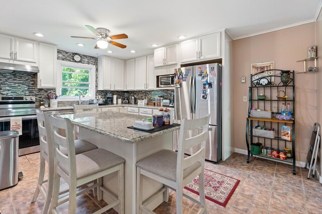 2975 Rte 9, Cold Spring, NY 10516 - kitchen with appliances with stainless steel finishes, under cabinet range hood, ceiling fan, decorative backsplash, and a breakfast bar