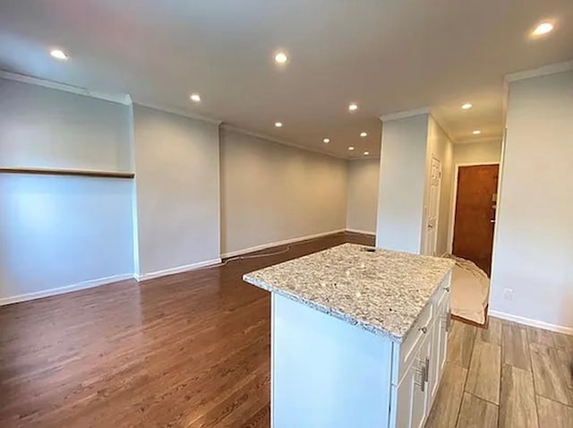 5840 Catalpa Ave, Ridgewood, NY 11385 - kitchen featuring ornamental molding, white cabinets, dark wood finished floors, a center island, and light stone counters