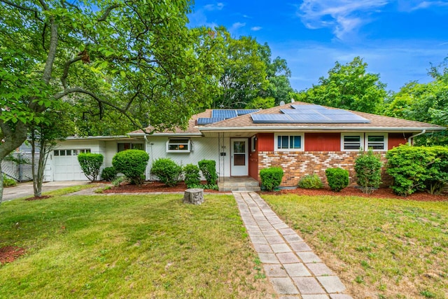 537 Sterling St, Uniondale, NY 11553 - ranch-style home with a front yard, asphalt driveway, roof mounted solar panels, brick siding, and an attached garage