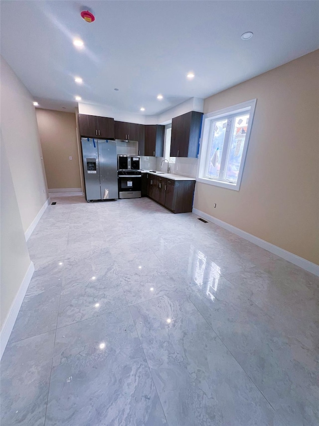 208-04 47th Ave, Bayside, NY 11361 - kitchen featuring appliances with stainless steel finishes, dark brown cabinets, light countertops, a sink, and baseboards