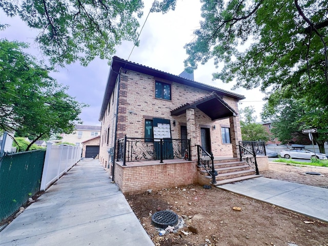208-04 47th Ave, Bayside, NY 11361 - view of front facade with brick siding, a detached garage, and a chimney