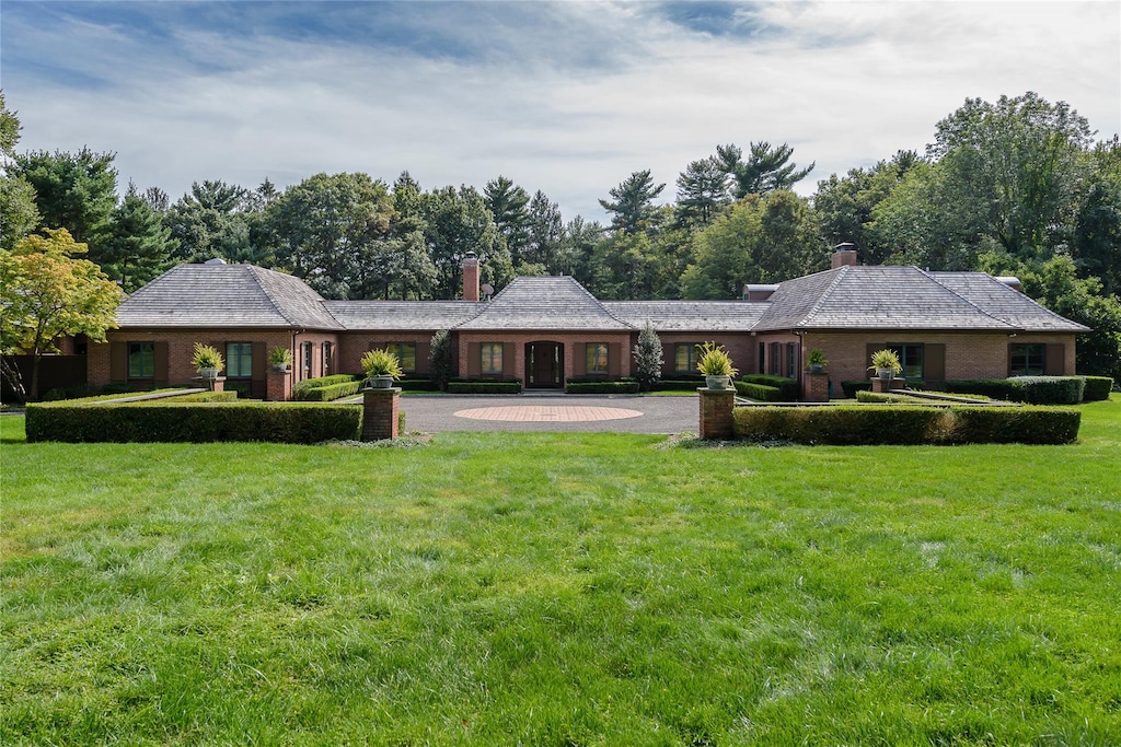 150 Horseshoe Rd, Mill Neck, NY 11765 - rear view of house with a chimney, a lawn, curved driveway, and brick siding