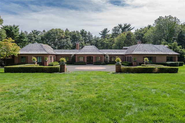 150 Horseshoe Rd, Mill Neck, NY 11765 - rear view of house with a chimney, a lawn, curved driveway, and brick siding