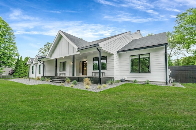 57 Varsity Blvd, East Setauket, NY 11733 - rear view of house featuring board and batten siding, covered porch, and a chimney
