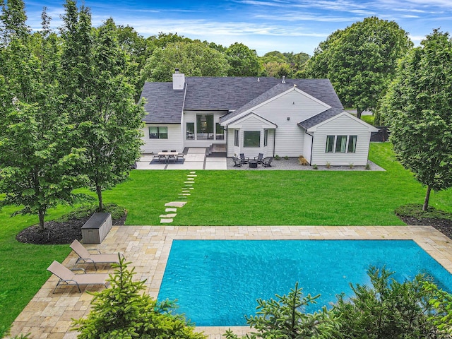 57 Varsity Blvd, East Setauket, NY 11733 - rear view of house with a patio area, a chimney, a yard, and an outdoor pool