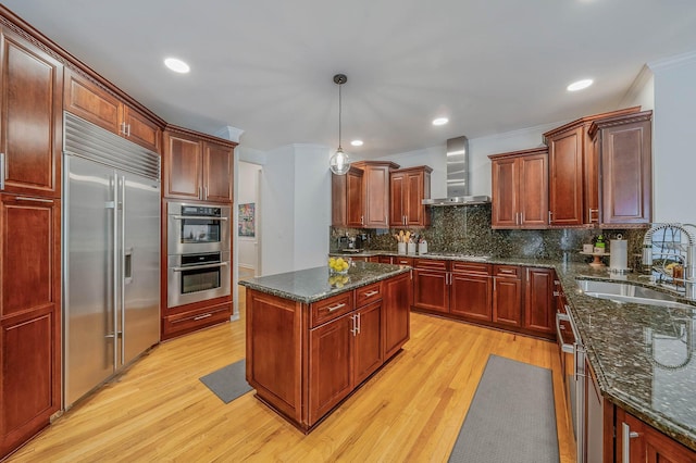 57 Varsity Blvd, East Setauket, NY 11733 - kitchen with a sink, stainless steel appliances, wall chimney exhaust hood, light wood finished floors, and tasteful backsplash