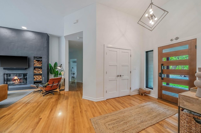 57 Varsity Blvd, East Setauket, NY 11733 - entrance foyer featuring light wood-type flooring, baseboards, a high ceiling, and a fireplace