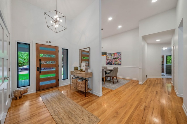 57 Varsity Blvd, East Setauket, NY 11733 - foyer featuring high vaulted ceiling, plenty of natural light, a chandelier, light wood-type flooring, and baseboards