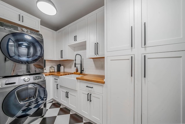 57 Varsity Blvd, East Setauket, NY 11733 - laundry area featuring stacked washer / drying machine, cabinet space, and dark flooring