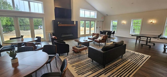 57 Varsity Blvd, East Setauket, NY 11733 - living room featuring high vaulted ceiling, a large fireplace, wood finished floors, a wainscoted wall, and french doors
