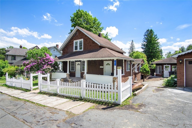 7 Lake St, Monticello, NY 12701 - view of front facade with a porch, a fenced front yard, and roof with shingles