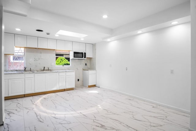 7 Lake St, Monticello, NY 12701 - kitchen featuring white microwave, recessed lighting, light countertops, light marble finish floors, and white cabinets