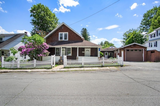 7 Lake St, Monticello, NY 12701 - view of front of property featuring covered porch, a fenced front yard, driveway, and an outdoor structure