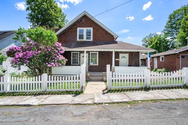 7 Lake St, Monticello, NY 12701 - view of front of house featuring a porch, a shingled roof, and a fenced front yard