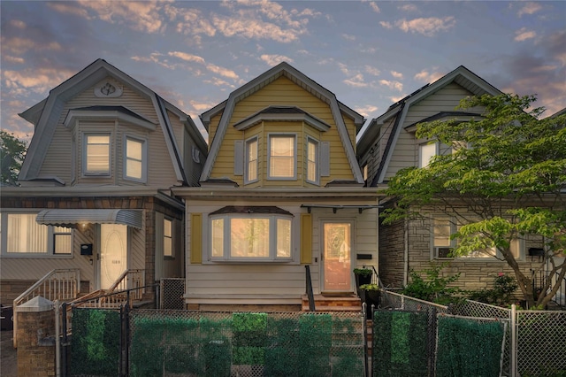 102-13 85th Ave, Richmond Hill, NY 11418 - colonial inspired home with a gambrel roof, a fenced front yard, entry steps, and a gate