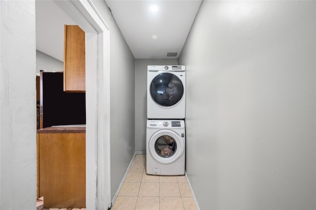 102-13 85th Ave, Richmond Hill, NY 11418 - laundry room with stacked washer and clothes dryer, light tile patterned flooring, and baseboards