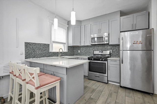 27-34 Mcintosh St, East Elmhurst, NY 11369 - kitchen with appliances with stainless steel finishes, a peninsula, gray cabinetry, and light countertops