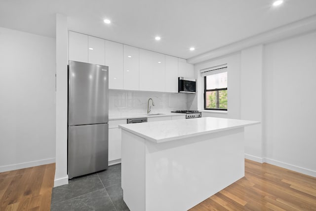 25-10 31st Ave Unit 2M, Astoria, NY 11106 - kitchen featuring freestanding refrigerator, modern cabinets, a sink, range, and white cabinetry