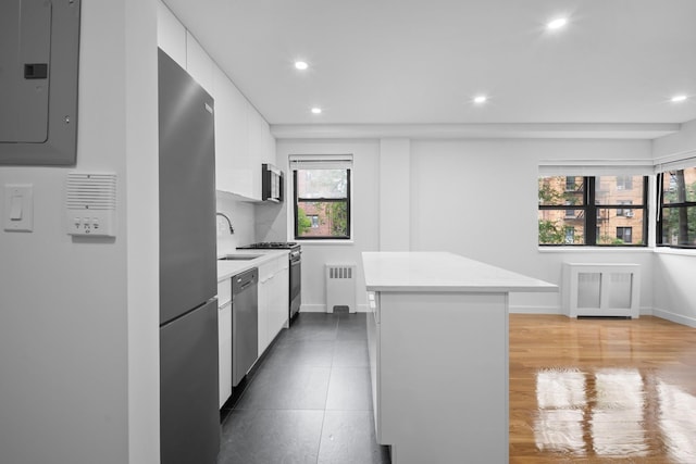 25-10 31st Ave Unit 2M, Astoria, NY 11106 - kitchen featuring radiator, electric panel, appliances with stainless steel finishes, a center island, and recessed lighting