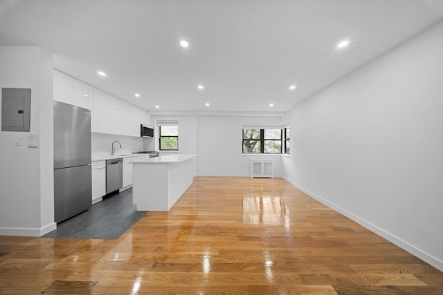 25-10 31st Ave Unit 2M, Astoria, NY 11106 - kitchen with appliances with stainless steel finishes, electric panel, light countertops, white cabinetry, and modern cabinets