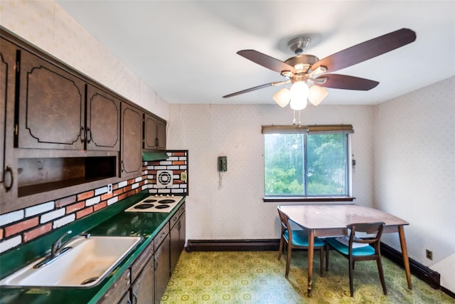 65 Cedar Ct, Copiague, NY 11726 - kitchen featuring dark brown cabinets, white electric stovetop, a baseboard heating unit, wallpapered walls, and a sink