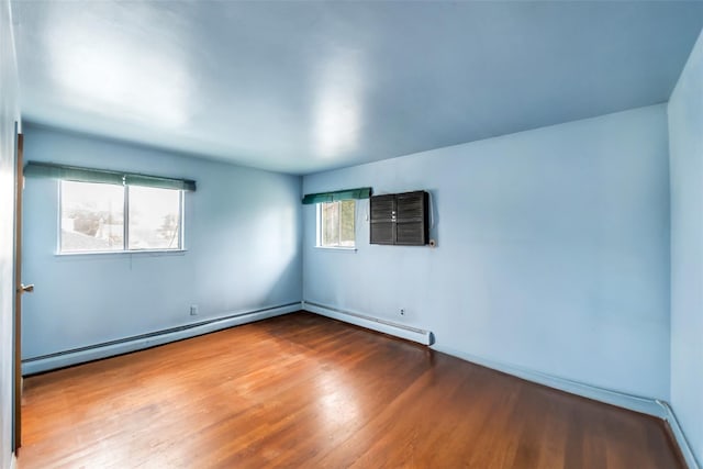 65 Cedar Ct, Copiague, NY 11726 - spare room featuring wood finished floors, a baseboard heating unit, and baseboards