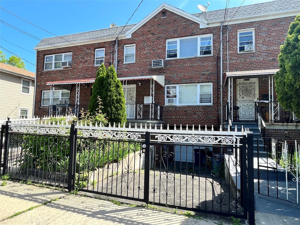 3128 Mickle Ave, Bronx, NY 10469 - townhome / multi-family property with brick siding, a fenced front yard, and cooling unit