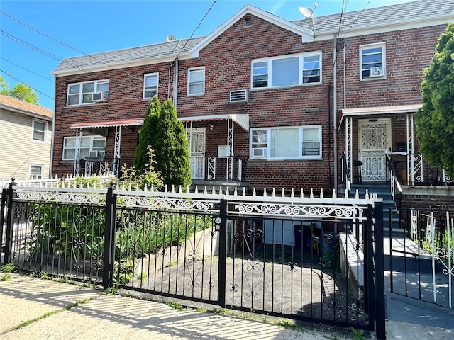 3128 Mickle Ave, Bronx, NY 10469 - townhome / multi-family property with brick siding, a fenced front yard, and cooling unit