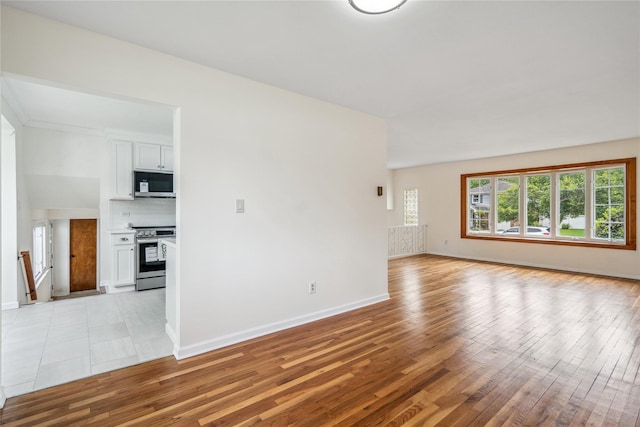 6 Poppy Dr, Massapequa Park, NY 11762 - unfurnished living room featuring light wood-style flooring and baseboards