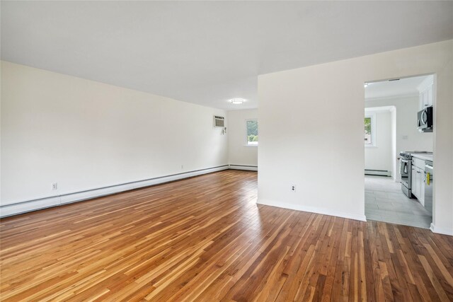 6 Poppy Dr, Massapequa Park, NY 11762 - empty room with a baseboard heating unit, a wall mounted AC, wood-type flooring, and baseboards