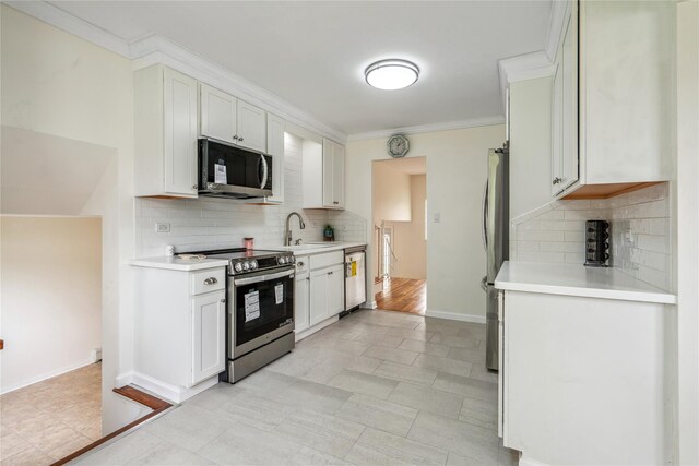 6 Poppy Dr, Massapequa Park, NY 11762 - kitchen with appliances with stainless steel finishes, tasteful backsplash, light countertops, a sink, and white cabinets